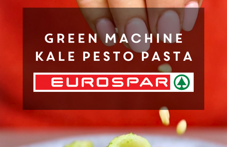 Picture of hand putting pine nuts on pasta background of image. Text on image that says Green Machine Kale Pesto Pasta